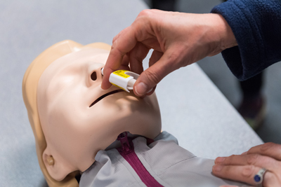 A nurse practices administering the nasal spray