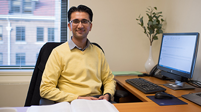 University of Michigan faculty member sits at desk