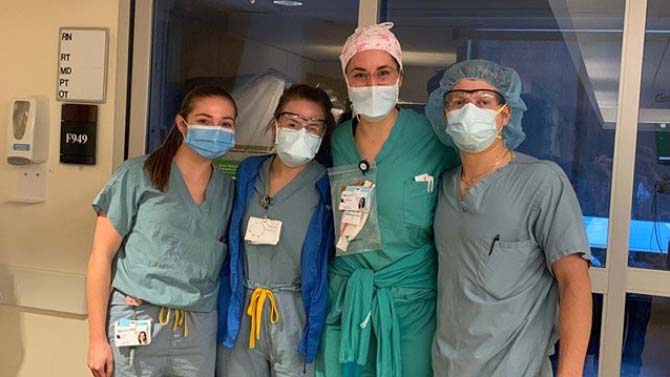 Group of alumni standing together in PPE