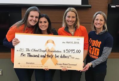 UMSN students Olivia Livernois and Kelly Creal presenting a check from NSG to Tammi Carr and Bree Arvai 