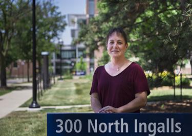 Grimshaw stands in front of the building where she was born. The School of Nursing can be seen in the background.