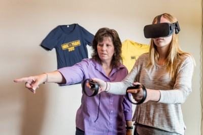 Michelle Aebersold guides a student during a simulation exercise with the Oculus Rift.